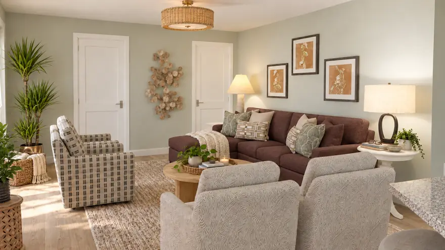 Family room design: plum sectional, patterned armchairs, round wood coffee table, sage walls and framed botanicals